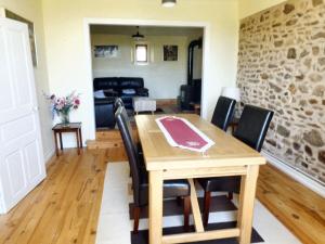 a dining room and living room with a table and chairs at Maison charmante à Mercœur avec jardin et parking in Mercoeur