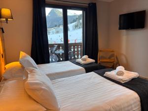 two beds in a hotel room with a window at Résidence Frond'Neige in Morzine
