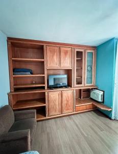 a large wooden entertainment center with a tv and a microwave at Pousada DRIRIOS HOUSE in Jaraguá do Sul