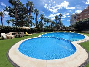 una piscina en un complejo con palmeras en Mediterráneo Gourmet Stays, en Oropesa del Mar