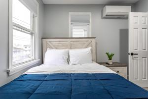 a bedroom with a blue and white bed with a window at Comfort Meets Style 3BR Plus Parking in New Rochelle