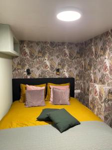 a yellow bed with two pillows on top of it at In Daaldersk Plakje in Deinum