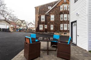 a table and chairs on a patio next to a building at Comfort Meets Style 3BR Plus Parking in New Rochelle