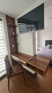 ein Zimmer mit einem Schreibtisch, einem Stuhl und einem Bett in der Unterkunft Nuevo Estudio de Lujo en el corazón de San Miguel in La Paz