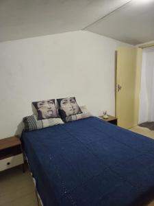 a bedroom with a blue bed with two faces on the pillows at Katai in Salvador