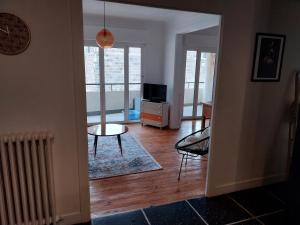 a living room with a table and a tv at Le Flow d'Issoire - Charmant appartement avec terrasse in Issoire