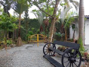 a bench and a gate in a garden with palm trees at Casa em Penha in Penha