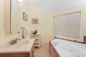 ein Badezimmer mit Badewanne und Waschbecken und einem Fenster in der Unterkunft Tubing, Hiking and Jay Peak fun at the Cliff House in Montgomery + 22 Fotos