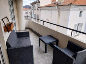 a balcony with two chairs and a bench on a building at Le Flow d'Issoire - Charmant appartement avec terrasse in Issoire