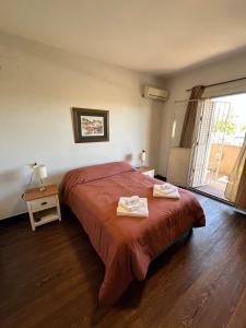 a bedroom with a bed with two towels on it at Casa Dos Avenidas 4 Dormitorios in Montevideo