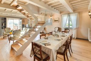 a dining room with a table and a staircase at Villa le Cipresse in Impruneta