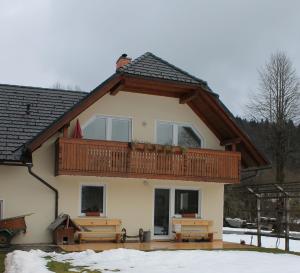 a house with a deck on top of it at Apartments Kovačič in Bohinj