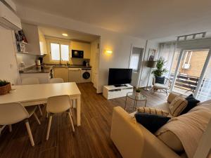ein Wohnzimmer mit Sofa und Tisch in der Unterkunft Apartamento de 2 habitaciones en primera línea con vistas al mar in Platja de l'Arenal