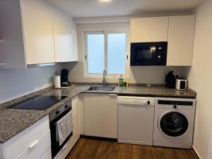 eine Küche mit Spüle und Waschmaschine in der Unterkunft Apartamento de 2 habitaciones en primera línea con vistas al mar in Platja de l'Arenal