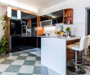 a kitchen with black cabinets and a checkered floor at Deluxe Apartman Dubrovnik in Dubrovnik