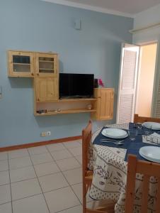 a dining room with a table and a tv at Holiday Maio in Calheta Do Maio