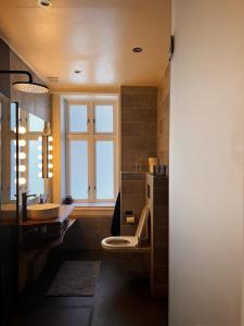 Un baño con inodoro, lavabo y ventana. en Hygge houses l Cozy, Central 1BR Apt in the best part of Oslo l Sleep 3, en Oslo