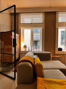 Una sala de estar con un sofá y dos ventanas. en Hygge houses l Cozy, Central 1BR Apt in the best part of Oslo l Sleep 3, en Oslo