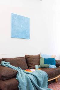 a living room with a brown couch with a blanket at 200 qm LOFT am Fluss für Freunde und Familien ! in Berlin