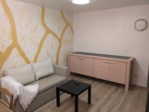 a living room with a couch and a clock on a wall at Golden Tree in Riga +1 photo