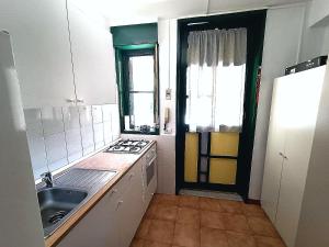 a small kitchen with a sink and a stove at Casa Iva in Schisò