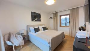 a bedroom with a large bed and a chair at Gästehaus im Grünen in Pesendorf