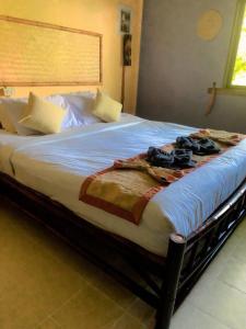 a large bed with clothes on it in a bedroom at khum dara lanta resort in Ko Lanta Yai