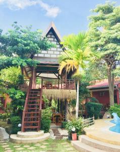 a house with a spiral staircase in front of it at khum dara lanta resort in Ko Lanta Yai