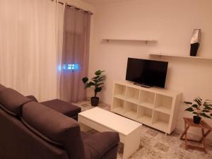 a living room with a couch and a flat screen tv at 'La Casa de la Motera' by Turismodecalidad in Algodonales