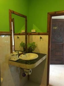 a bathroom with a sink and a green wall at khum dara lanta resort in Ko Lanta Yai