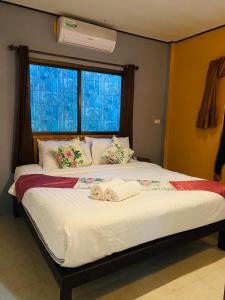 a bedroom with a large bed with a window at khum dara lanta resort in Ko Lanta Yai +26 photos