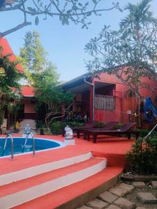a house with a pool and stairs next to a building at khum dara lanta resort in Ko Lanta Yai