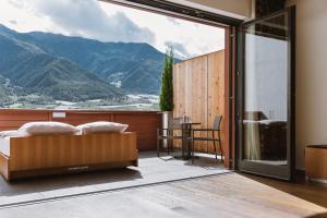 a bedroom with a view of a mountain at Lindenhof Pure Luxury & Spa DolceVita Resort in Naturno