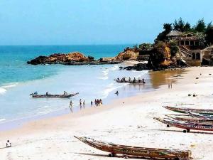 a beach with boats and people on the beach at Darrou Salam house in Rufisque