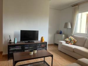 een woonkamer met een televisie en een bank bij Casa La Marina spacious apartment 100m in La Marina