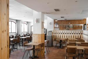 a dining room with wooden tables and chairs at Hôtel Valfréjus Vacances in Valfréjus