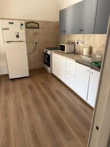 Una cocina con gabinetes blancos y un refrigerador blanco. en D Pitsillos Homes luxury, en Lárnaca