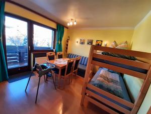 Cette chambre comprend une table et des lits superposés. dans l'établissement Susis Apartment Altenmarkt, à Altenmarkt im Pongau