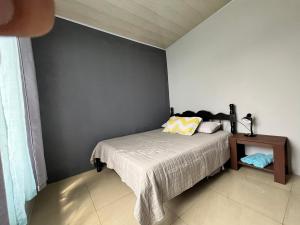 a bedroom with a bed and a side table at Bellavista Ceci A2 in San Ramón