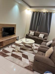 a living room with a couch and a table at سكناي بارك للشقق المخدومة in Arar