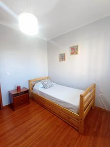 1 dormitorio con cama de madera y suelo de madera en Village Sea House - Porto Moniz, en Porto Moniz