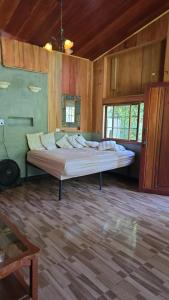 a large bed in a room with wooden walls at Cabaña Rio Diamante in San Luis