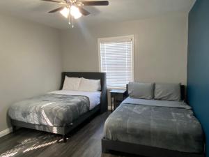 a bedroom with two beds and a ceiling fan at Faith House in Los Angeles