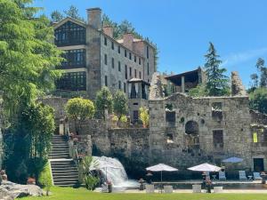 卡尔达斯·德·雷斯托雷多里奥酒店的一座大型石头建筑,前面有瀑布