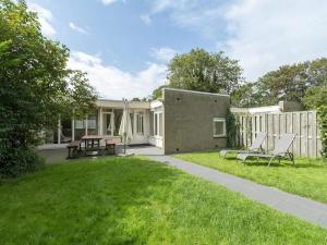 une arrière-cour d'une maison avec une table et des chaises dans l'établissement Nice bungalow near beach for 5 guest, à Sint Maartenszee