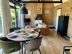 a dining room with a table and chairs and a living room at Bungalow in dune area of Sint Maartenszee in Sint Maartenszee