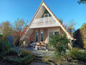 a house with a table and chairs in front of it at Cozy holiday home in Sint Maartenszee in Sint Maartenszee
