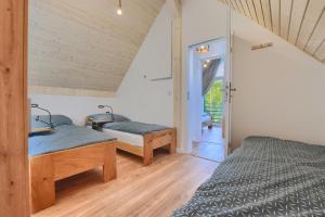 a bedroom with two beds and a door to a balcony at Osada Pod Maliną in Brenna