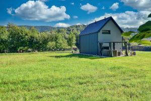 a blue and white barn in a field at Osada Pod Maliną in Brenna