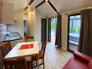 una cucina e una sala da pranzo con tavolo e sedie di Bungalow in Dziwnów near Baltic Sea Promenade a Dziwnów